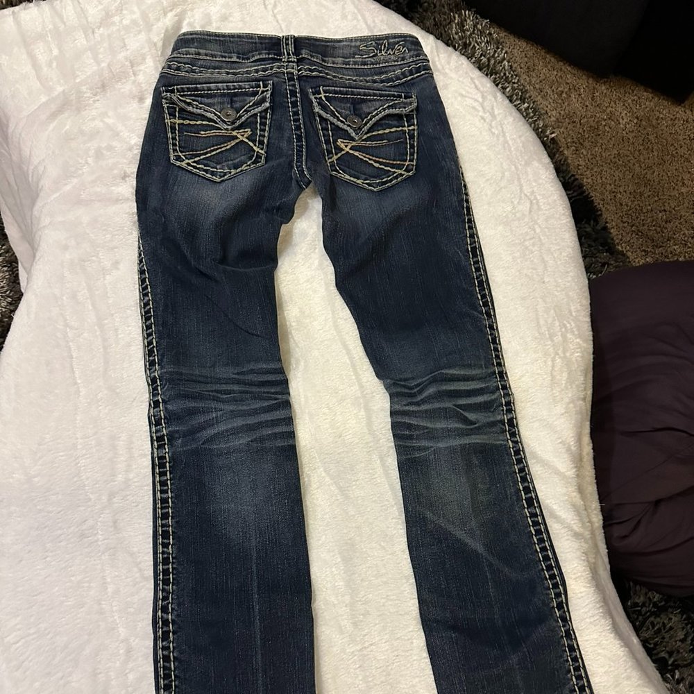 Silver denim slim bootcut jeans.  Embroidered, buttoned back pockets.  Size 24